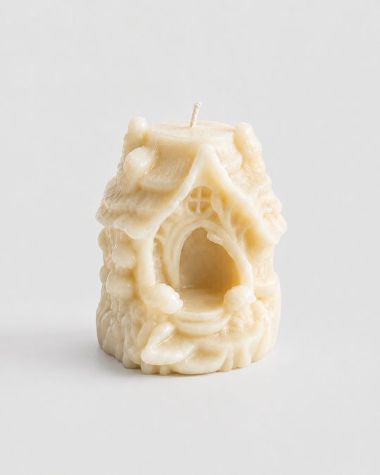 Grey Exim Hollow French Vanilla candle shaped as a fairy house with pitched roof and arched entrance, front view
